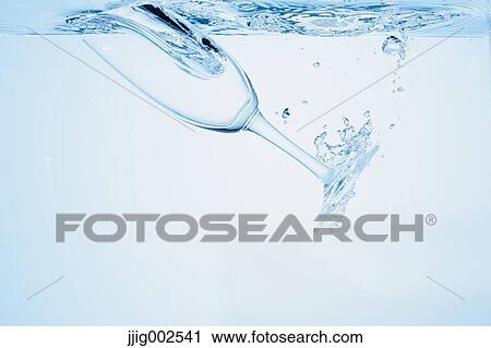 Stock Image - Champagne glass falling into water. Fotosearch