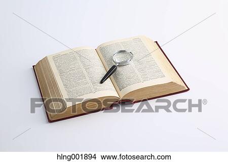 Picture - Dictionary and magnifying glass. Fotosearch