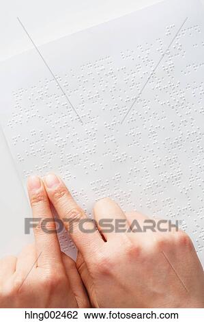 Stock Image - Hands reading Braille paper. Fotosearch