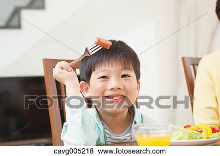 Japanese boy eating in the kitchen View Large Photo Image Stock Photo - Japanese boy eating in the kitchen. Fotosearch