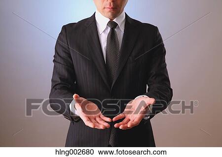 Stock Image - Japanese businessman using virtual reality device. Fotosearch