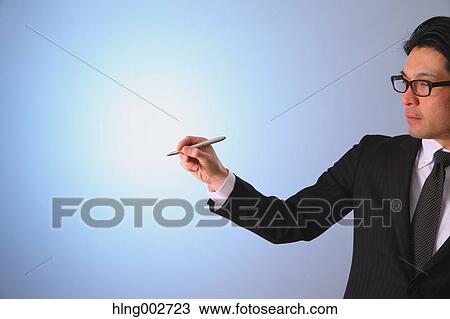 Stock Image - Japanese businessman using virtual reality device. Fotosearch