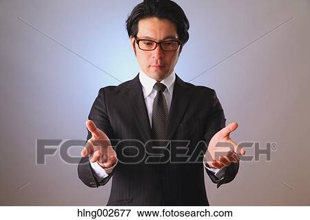 Stock Photo - Japanese businessman using virtual reality device. Fotosearch
