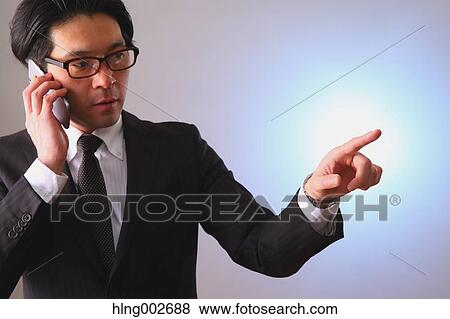 Stock Photo - Japanese businessman using virtual reality device. Fotosearch