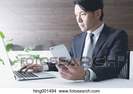 Japanese businessman working with large display smartphone View Large Photo Image Picture - Japanese businessman working with large display smartphone. Fotosearch