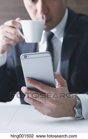 Japanese businessman working with large display smartphone View Large Photo Image Stock Image - Japanese businessman working with large display smartphone. Fotosearch