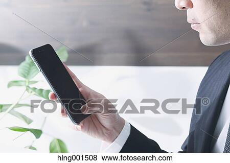 Japanese businessman working with large display smartphone View Large Photo Image Stock Photo - Japanese businessman working with large display smartphone. Fotosearch