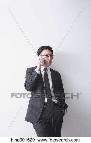 Stock Photo - Japanese businessman working with large display smartphone. Fotosearch
