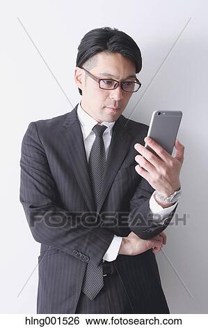 Japanese businessman working with large display smartphone View Large Photo Image Stock Photograph - Japanese businessman working with large display smartphone. Fotosearch