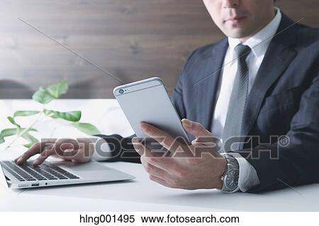 Japanese businessman working with large display smartphone View Large Photo Image Stock Photography - Japanese businessman working with large display smartphone. Fotosearch