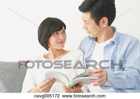 Japanese couple on the sofa with book View Large Photo Image Stock Image - Japanese couple on the sofa with book. Fotosearch