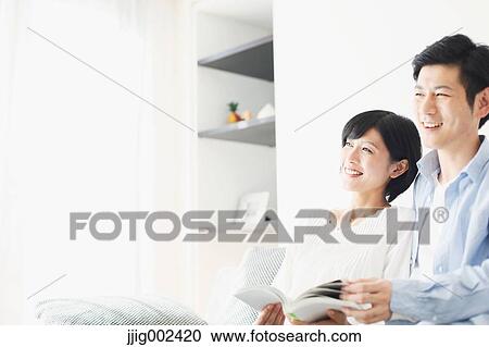 Japanese couple on the sofa with book View Large Photo Image Stock Image - Japanese couple on the sofa with book. Fotosearch