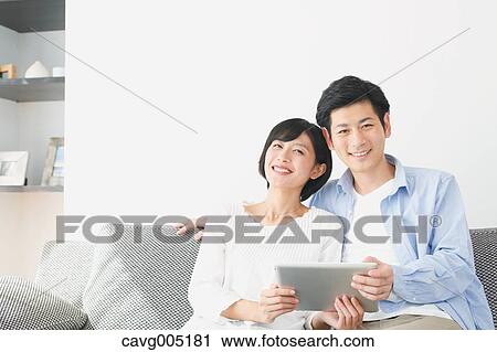 Japanese couple on the sofa with tablet View Large Photo Image Stock Image - Japanese couple on the sofa with tablet. Fotosearch