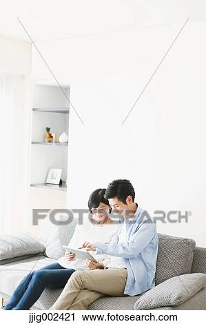 Japanese couple on the sofa with tablet View Large Photo Image Stock Image - Japanese couple on the sofa with tablet. Fotosearch