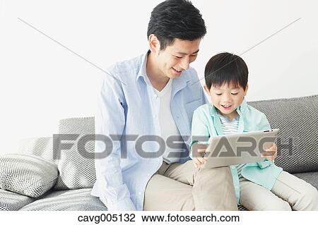 Japanese father and son on the sofa with tablet View Large Photo Image Stock Image - Japanese father and son on the sofa with tablet. Fotosearch