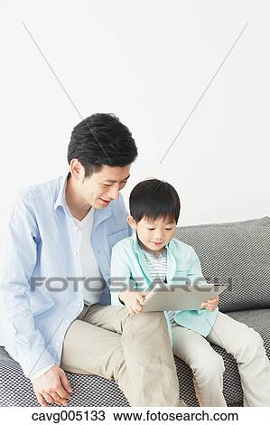 Japanese father and son on the sofa with tablet View Large Photo Image Stock Image - Japanese father and son on the sofa with tablet. Fotosearch