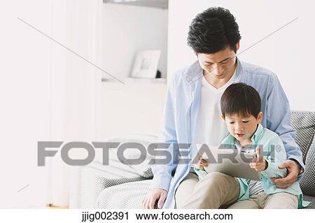 Japanese father and son on the sofa with tablet View Large Photo Image Stock Image - Japanese father and son on the sofa with tablet. Fotosearch