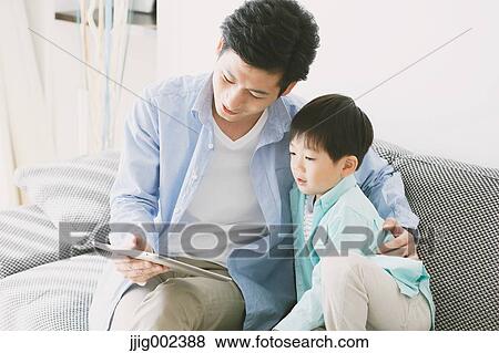 Japanese father and son on the sofa with tablet View Large Photo Image Stock Photo - Japanese father and son on the sofa with tablet. Fotosearch