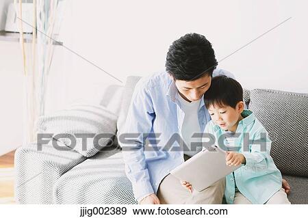 Japanese father and son on the sofa with tablet View Large Photo Image Stock Photo - Japanese father and son on the sofa with tablet. Fotosearch