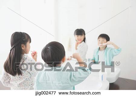 Stock Photo - Japanese kid brushing teeth in the bathroom. Fotosearch
