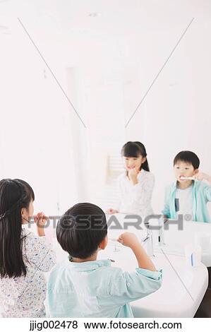 Stock Photo - Japanese kid brushing teeth in the bathroom. Fotosearch