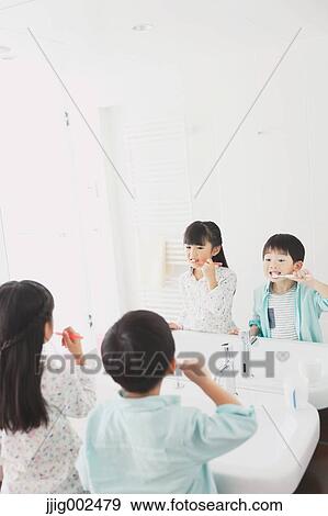 Stock Photo - Japanese kid brushing teeth in the bathroom. Fotosearch