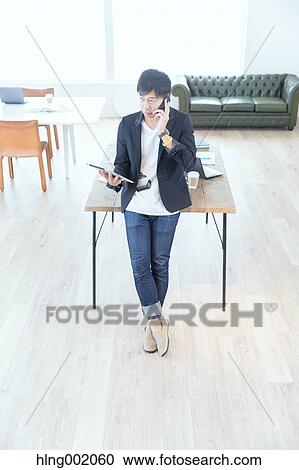 Stock Image - Japanese man working in modern office. Fotosearch