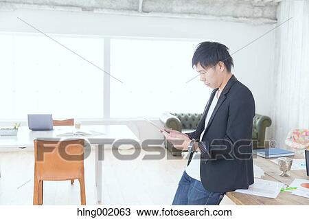 Japanese man working in modern office View Large Photo Image Stock Image - Japanese man working in modern office. Fotosearch