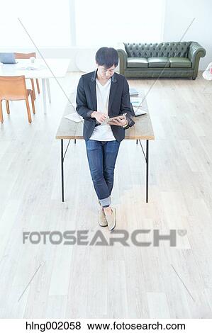Japanese man working in modern office View Large Photo Image Stock Photo - Japanese man working in modern office. Fotosearch