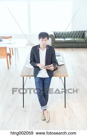 Stock Photo - Japanese man working in modern office. Fotosearch
