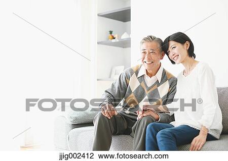 Stock Image - Japanese senior and daughter on the sofa. Fotosearch