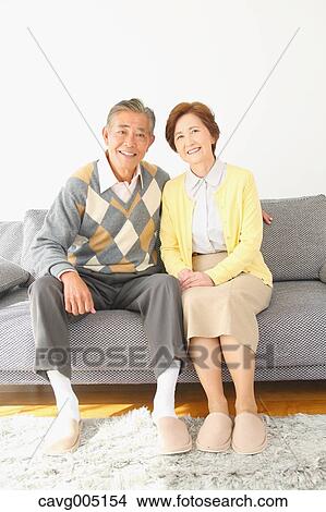 Picture - Japanese senior couple on the sofa. Fotosearch