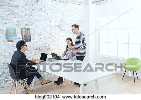 Picture - Multi-ethnic business people working in modern office. Fotosearch