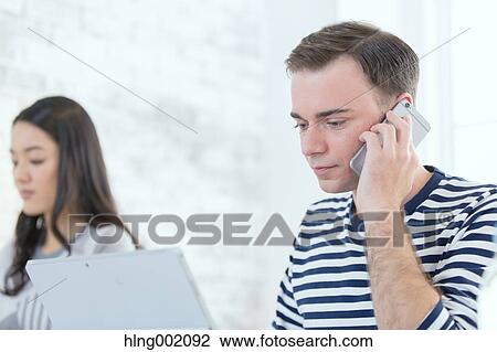 Stock Image - Multi-ethnic business people working in modern office. Fotosearch