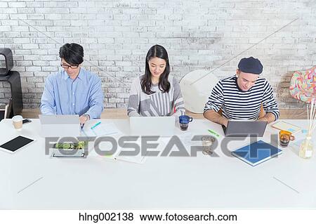 Stock Photo - Multi-ethnic business people working in modern office. Fotosearch