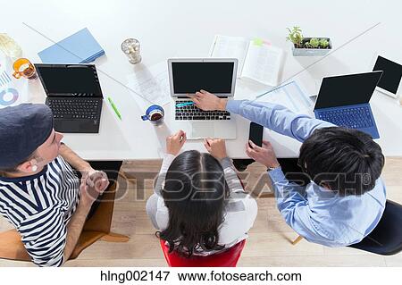 Stock Photo - Multi-ethnic business people working in modern office. Fotosearch