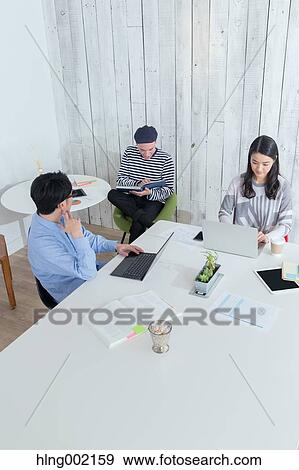 Stock Photo - Multi-ethnic business people working in modern office. Fotosearch