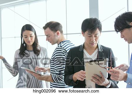 Stock Photograph - Multi-ethnic business people working in modern office. Fotosearch