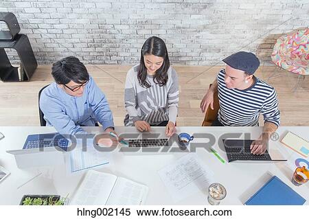Stock Photography - Multi-ethnic business people working in modern office. Fotosearch