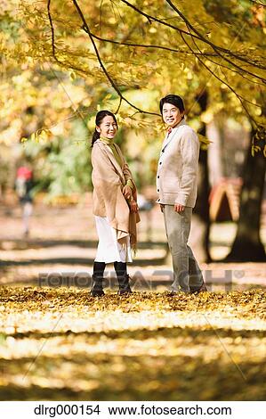 Picture - Senior Japanese couple in a city park in Autumn. Fotosearch