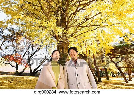 Picture - Senior Japanese couple in a city park in Autumn. Fotosearch