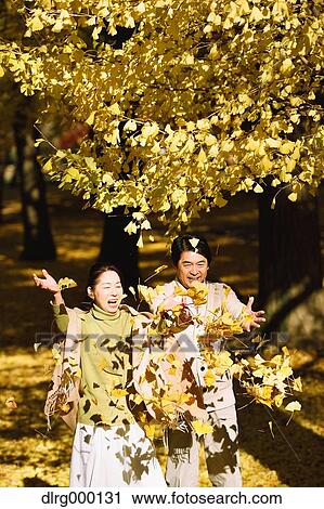 Stock Image - Senior Japanese couple in a city park in Autumn. Fotosearch