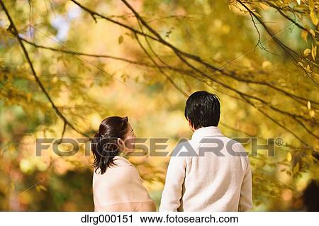 Stock Image - Senior Japanese couple in a city park in Autumn. Fotosearch