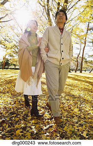 Stock Image - Senior Japanese couple in a city park in Autumn. Fotosearch