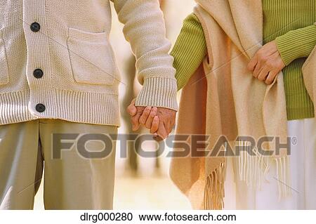 Stock Image - Senior Japanese couple in a city park in Autumn. Fotosearch