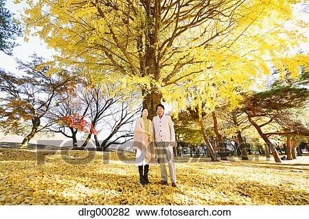 Stock Image - Senior Japanese couple in a city park in Autumn. Fotosearch