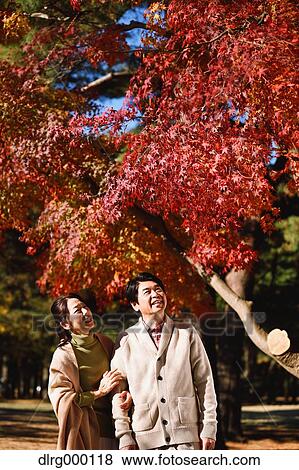 Stock Photo - Senior Japanese couple in a city park in Autumn. Fotosearch