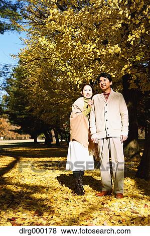 Stock Photo - Senior Japanese couple in a city park in Autumn. Fotosearch
