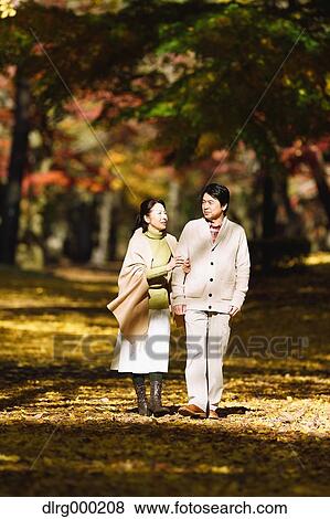 Stock Photo - Senior Japanese couple in a city park in Autumn. Fotosearch