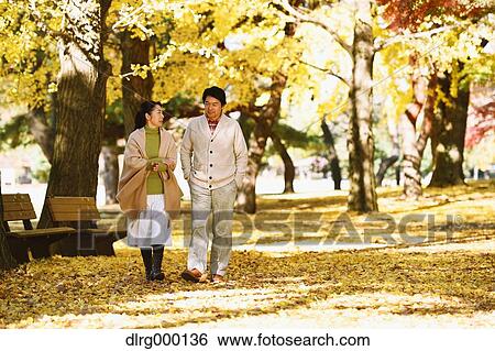 Stock Photograph - Senior Japanese couple in a city park in Autumn. Fotosearch